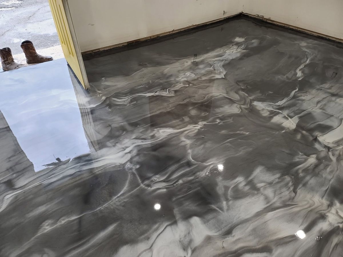 Silver and charcoal metallic epoxy floor with a marbled swirl